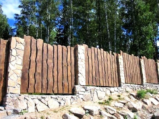 Деревянный забор со столбами из камня